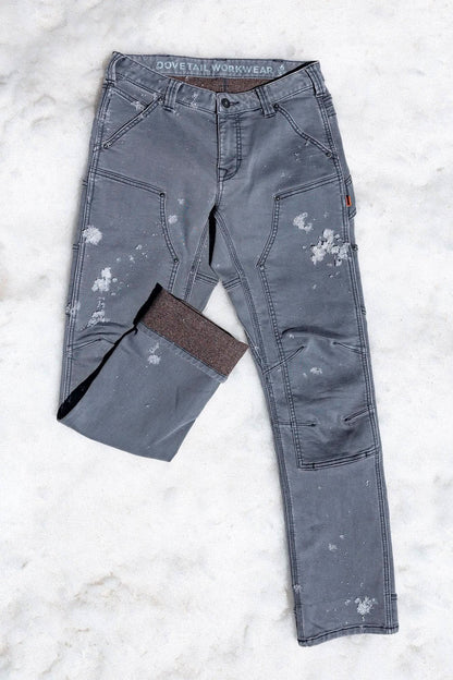 Britt Utility HOTSWAP™ Pants in grey thermal denim laid on snow, showing weather resistance and insulation for cold climate workwear.
