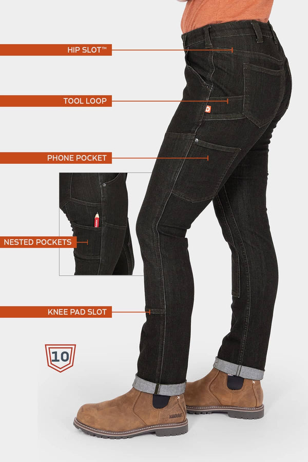 Side view of a woman wearing Dovetail Workwear's Maven Slim Pant in Heathered Black Graphene, highlighting the Hip Slot™, Tool Loop, Phone Pocket, Nested Pockets, and Knee Pad Slot features