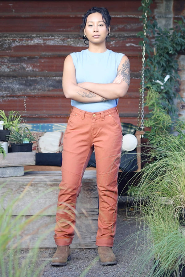 GO TO™ Stretch Canvas Pant in Terracotta by Dovetail Workwear shown in terracotta with reinforced knees, worn by a woman standing outdoors