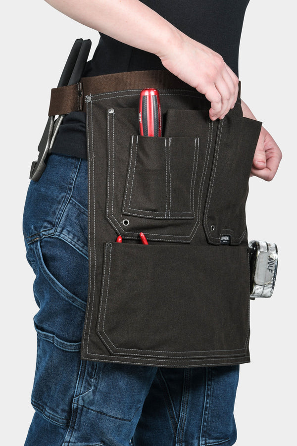 Dovetail Workwear Tool Apron in Kodiak Brown worn by a woman, displaying multiple pockets, hammer loops, and Twine Hole™ eyelets for workshop organization