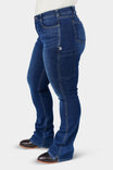 Side view of a woman wearing John Deere X Dovetail Workwear Into Town Bootcut Jeans in Classic Indigo Blue, featuring a mid-rise fit, thigh phone pocket, and split hem design over black boots