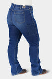 Back view of a woman wearing John Deere X Dovetail Workwear Into Town Bootcut Jeans in Classic Indigo Blue, showcasing the reinforced back pockets and bootcut silhouette designed to fit over boots