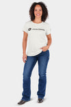 Woman wearing the John Deere X Dovetail Workwear Into Town Bootcut Jeans in Indigo Denim with a cream John Deere logo tee, posed against a white background