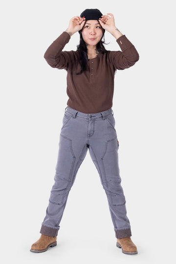 Woman wearing Britt Utility HOTSWAP™ Pant in grey thermal denim with rolled cuffs, showcasing insulated work pants for cold weather by Dovetail Workwear.