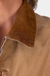 Detail view of the corduroy collar on the Old School Trucker Vest in Vintage Brown, shown on a woman wearing the quilted canvas vest