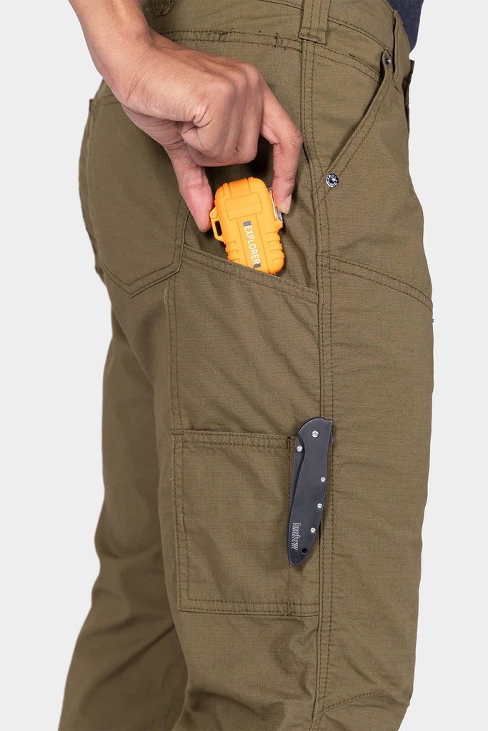 Detail shot of a woman's cargo pocket on the Dovetail Workwear Anna Ultralight Trail Pant in Kelp Green Ripstop, displaying the Hip Slot™ tool loop with a yellow multi-tool and nested pocket storage