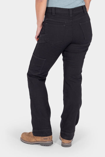 Back view of a woman wearing Dovetail Workwear's Britt Utility Pant in No Fade Black Canvas, featuring nested pockets, tool loop, and reinforced knees