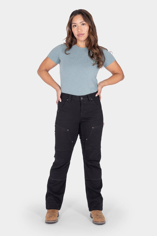 Dovetail Workwear Britt Utility Pant in No Fade Black Canvas worn by a woman with hands on hips, showing nested pockets, tool loop, and reinforced knees