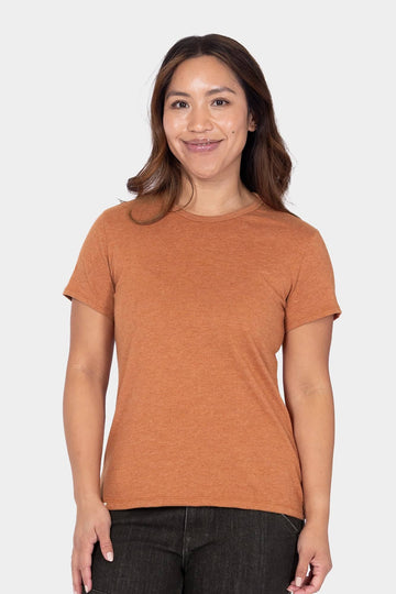 Woman wearing the Dovetail Workwear GO TO™ Crew Neck Tee Shirt in Faded Paprika Orange with dark jeans against a white background