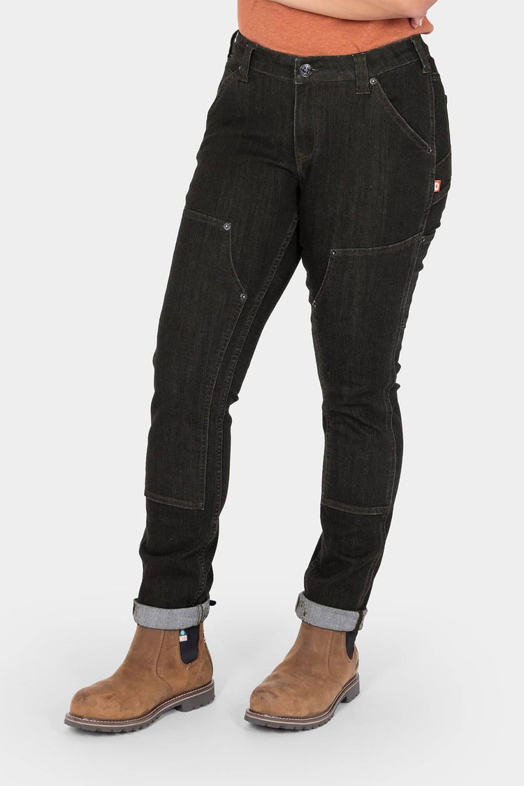 Maven Slim Pant in Heathered Black Graphene by Dovetail Workwear, shown cuffed on a woman wearing work boots, displaying reinforced thigh panels and nested pockets