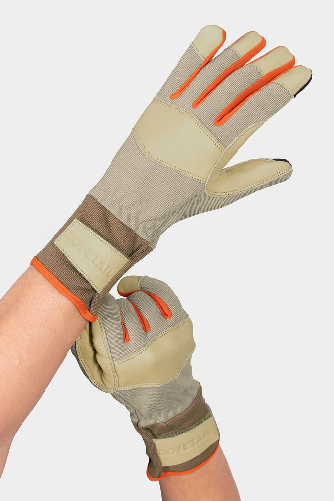 Dovetail Workwear Performance Work Gloves in Light Kodiak displayed on a woman's hands, featuring genuine leather, breathable stretch panels, adjustable wrist strap, and touchscreen-sensitive fingertips