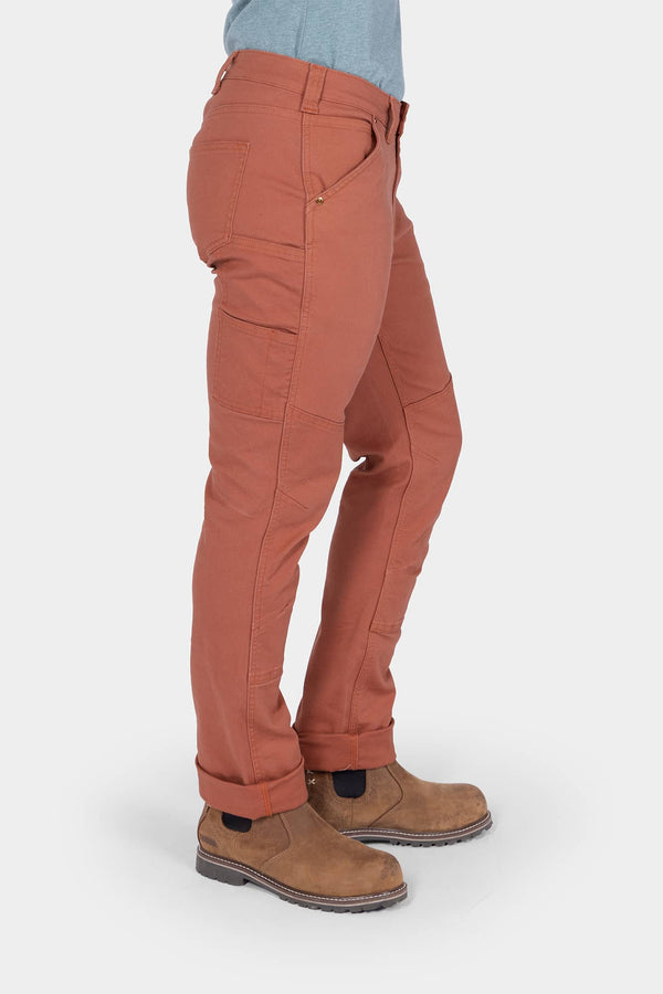 Side view of a woman wearing Dovetail Workwear GO TO™ Stretch Canvas Pant in Terracotta, showing reinforced knees and straight leg fit.