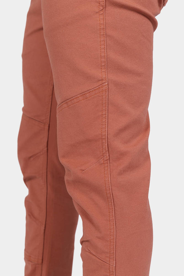 Side view of a woman wearing the GO TO™ Stretch Canvas Pant in Terracotta by Dovetail Workwear, highlighting the articulated knee and reinforced knee design
