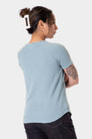 Back view of a woman wearing the Dovetail Workwear Old School Summer Henley in Shore Blue, showcasing the lightweight cotton blend waffle knit fabric and short sleeves