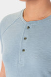 Close-up detail of the Old School Summer Henley Shirt by Dovetail Workwear in Shore Blue, featuring the button-front placket and cotton blend waffle knit fabric worn by a woman