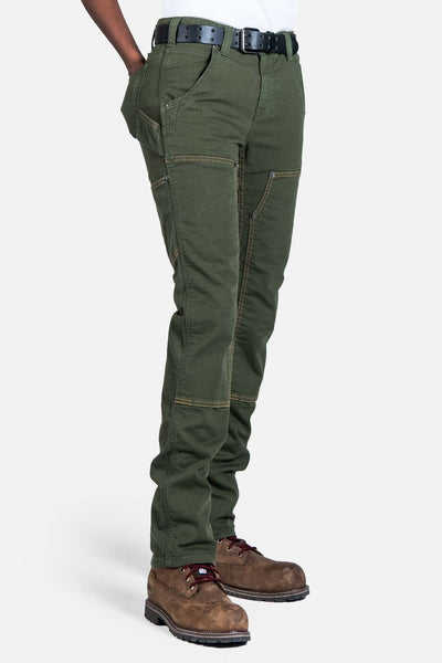 Side view of a woman wearing Dovetail Workwear's Maven X Pant in Moss Green Canvas, showcasing the slim leg fit, cargo pockets, and Reinforced Knees design